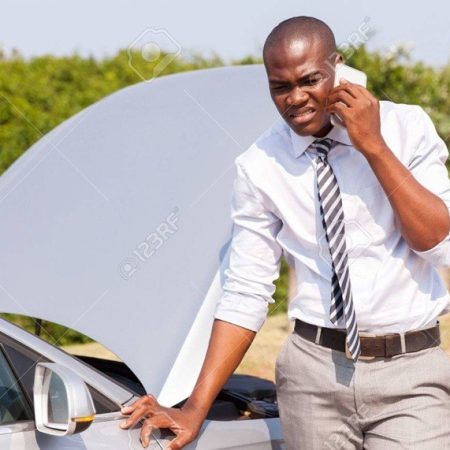 emergency loan young african man calling for assistance with his car broken down by the roadside