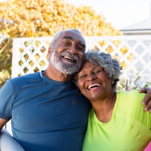 mstaafu-loan Smiling african american senior couple holding yoga mats in garden and looking at camera. active and healthy retirement lifestyle at home.